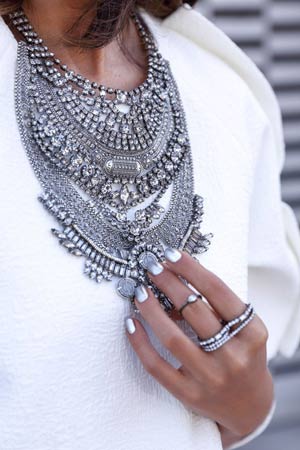 velika srebrna ogrlica uz belu bluzu